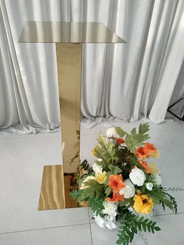 Düğün yemek masasının ortasındaki yüksek altın ayna sütun çiçek rafı